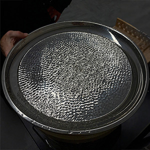 Cymatics water experiment showing sound vibrations creating rippling wave patterns on a liquid surface.